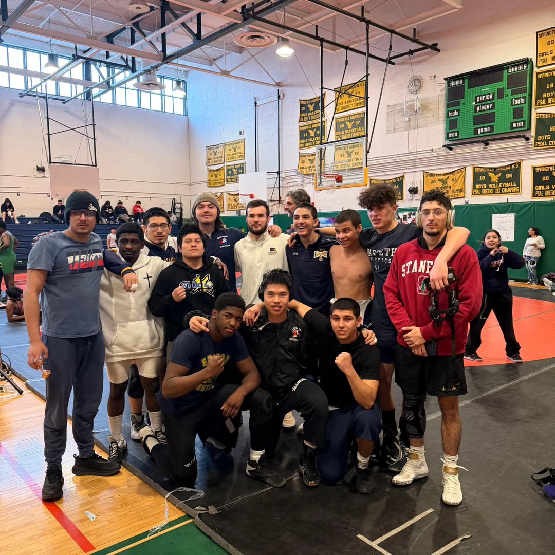 Studio X Wrestling squad and coaches gathered on the mat after competing at the city championships at Springfield Gardens High School